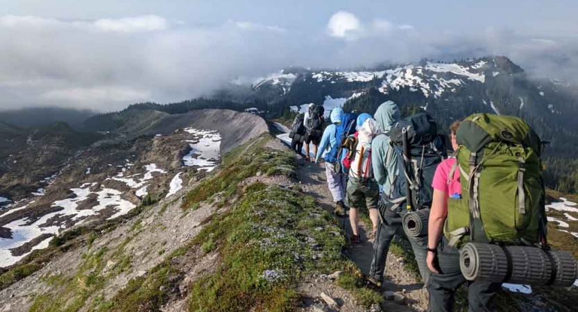 a group of students on a mountaineering course traverse a mountainous landscape